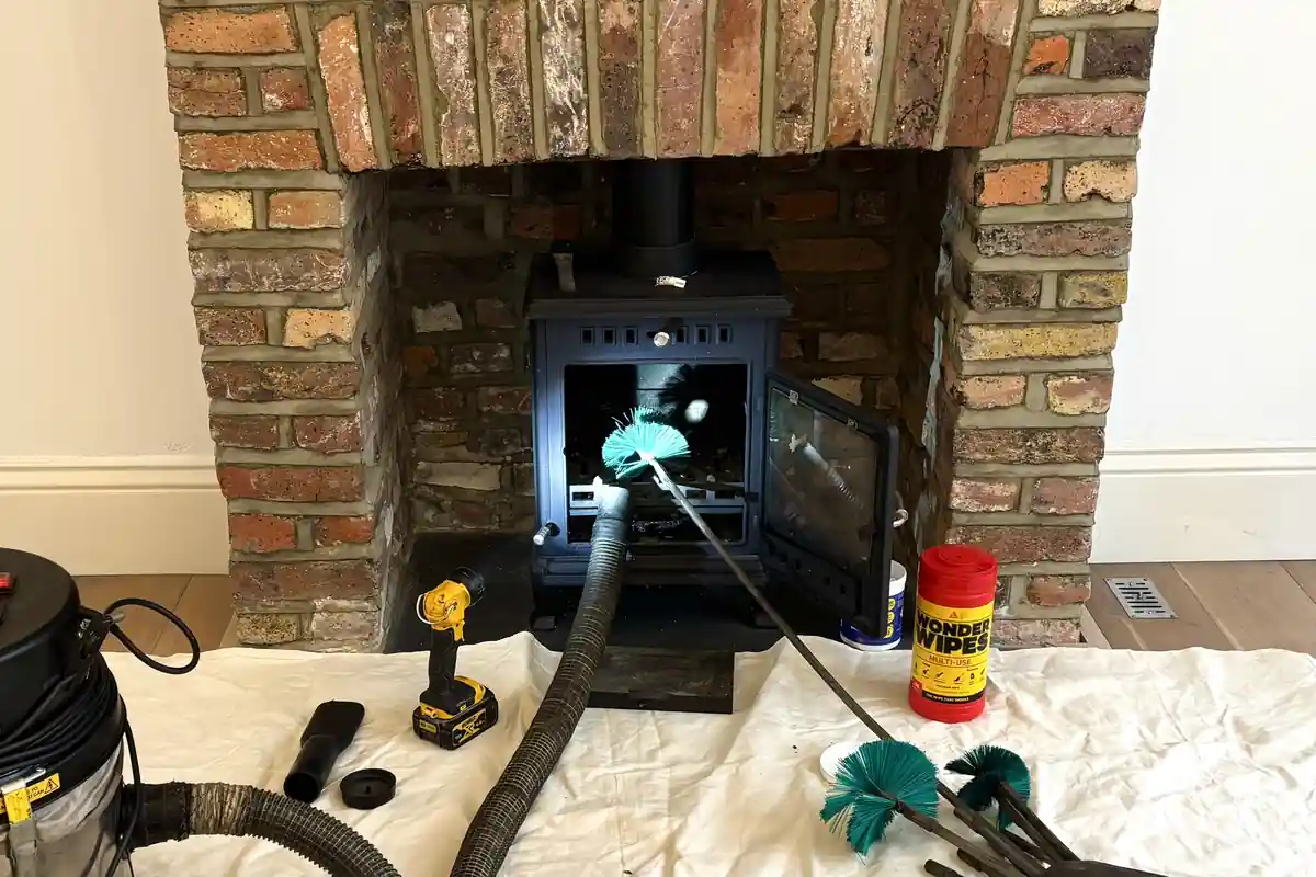 HETAS chimney sweep Romford — professional sweep in action with brush and dust sheets, Havering